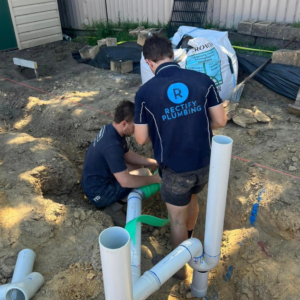 Rectify Plumbing plumber performing pipe repair and replacement outdoors