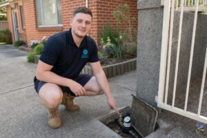 Licensed plumber showing homeowner how to locate and turn off the main water shutoff valve at Berowra Heights property