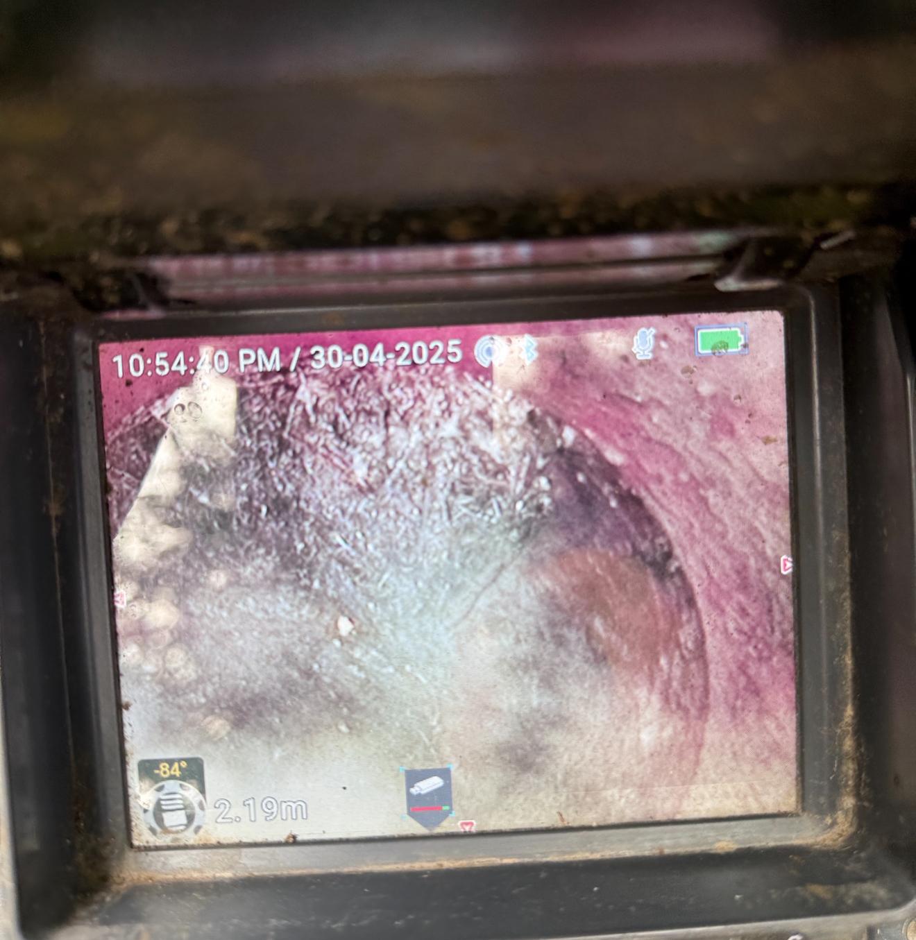 CCTV drain camera footage showing root intrusion and build-up inside a Central Coast sewer pipe