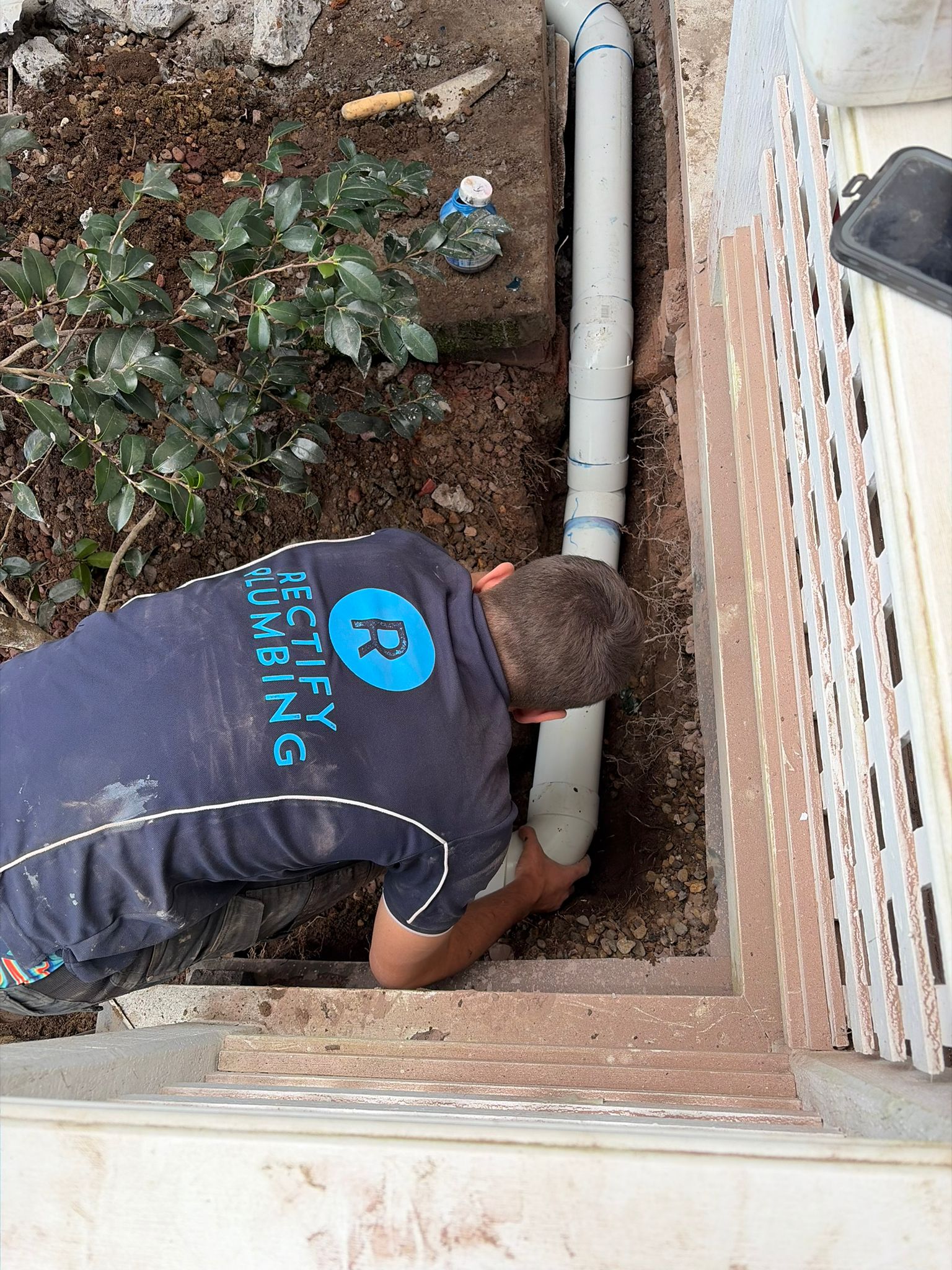 Rectify plumber checking an external overflow relief gully and drain inspection point at a Hornsby house