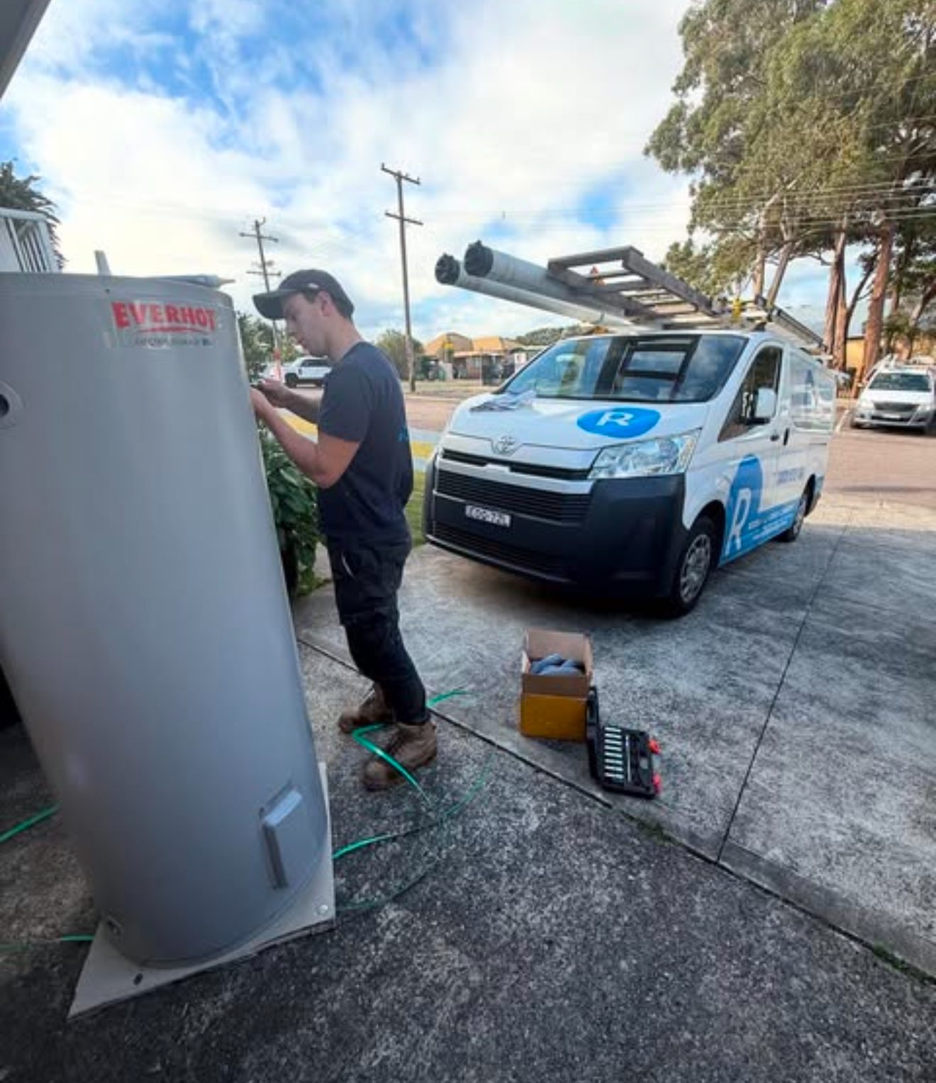 Rectify Plumbing plumber unloading a hot water tank from the branded work ute